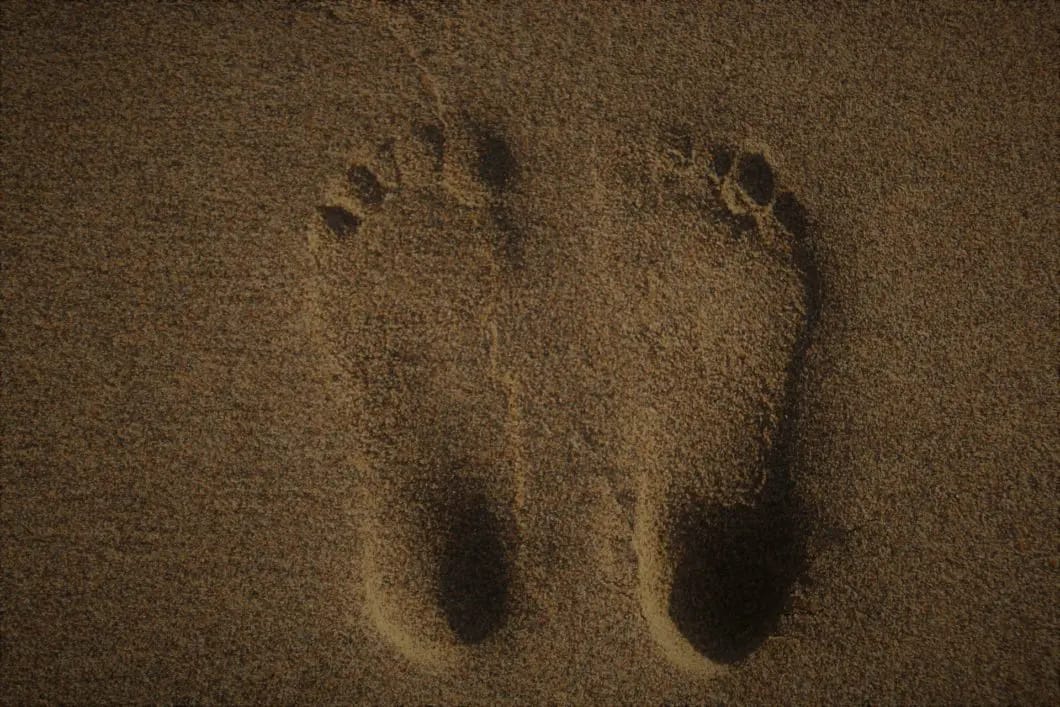Barfuß im Sand - ein paar Fußspuren beim Erden oder Earthing.