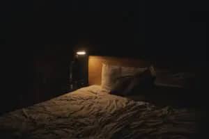 Ein Bett in Dunkelheit. Der Ort an dem Du die positiven Effekte auf Deine Gesundheit von Schlaf erntest.
